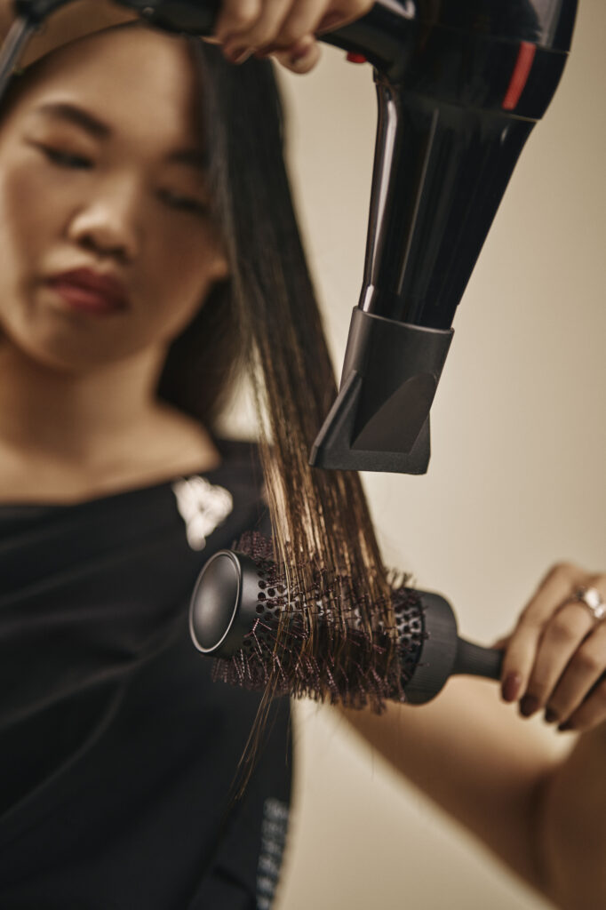 Hair being blow-dried after applying Aveda One For All Leave-In Elixir